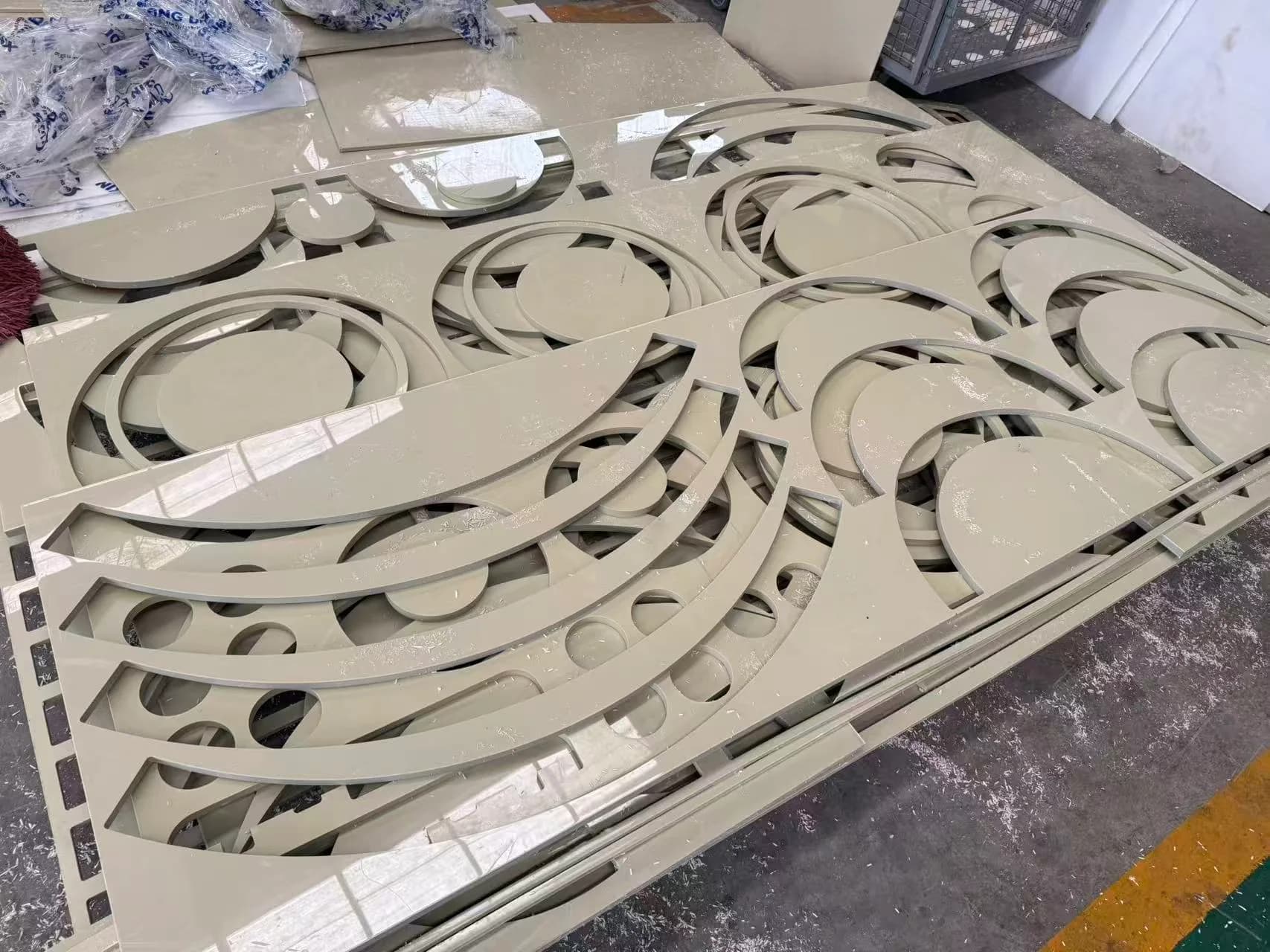 Nested ring-shaped plastic cutouts and parts on the workshop floor