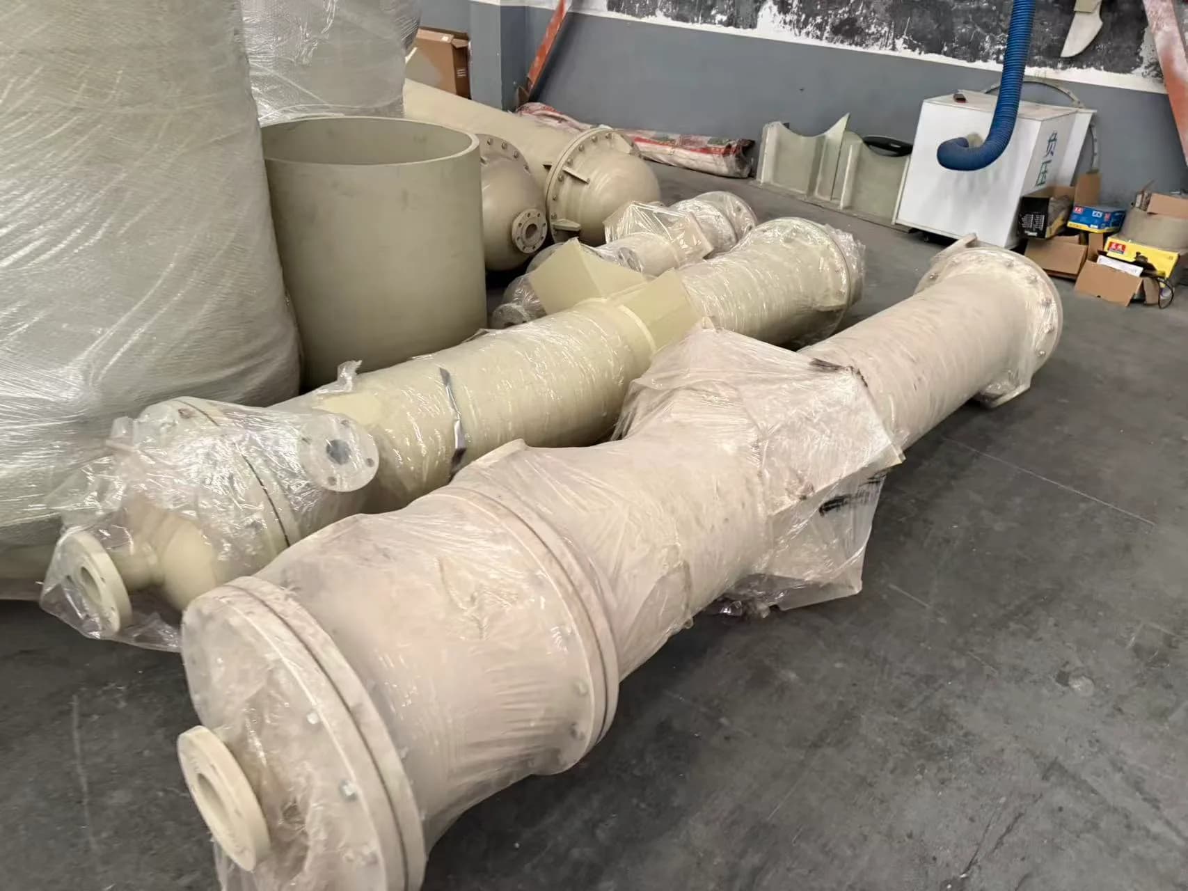 Wrapped plastic flanged components arranged on the workshop floor