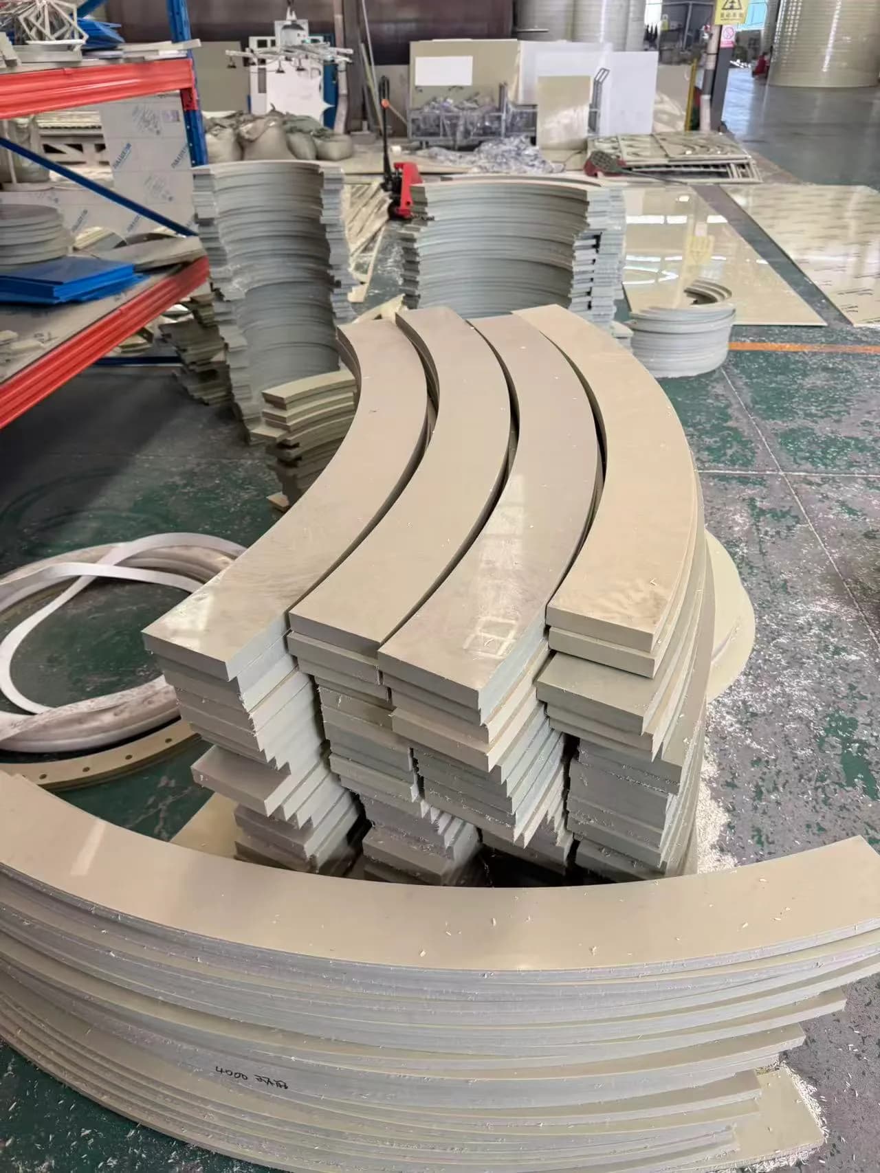 Cut curved plastic components stacked on the factory floor