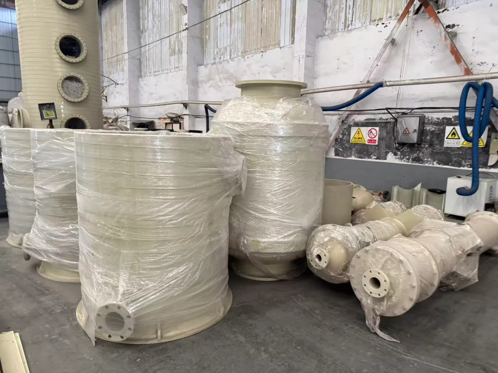 Wrapped plastic cylinders and flanged assemblies in the factory