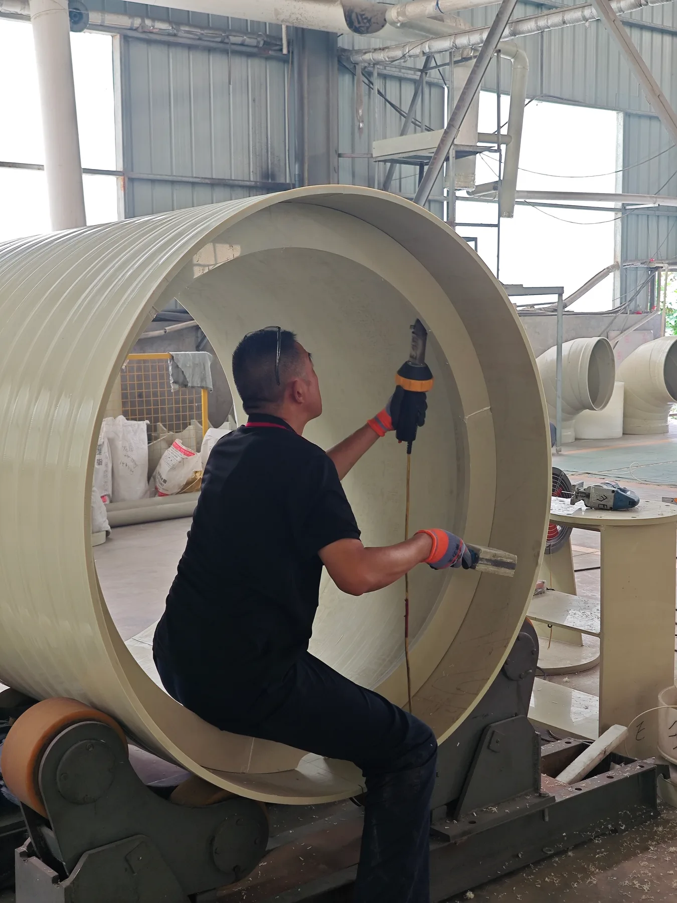 Worker welding inside a large plastic cylinder