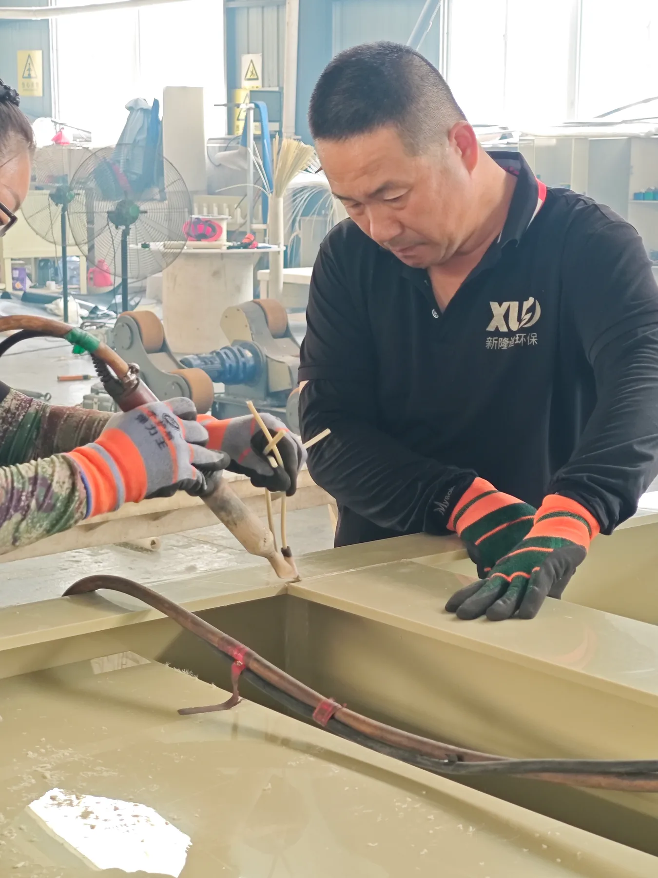 Xin Longdi worker welding a plastic assembly